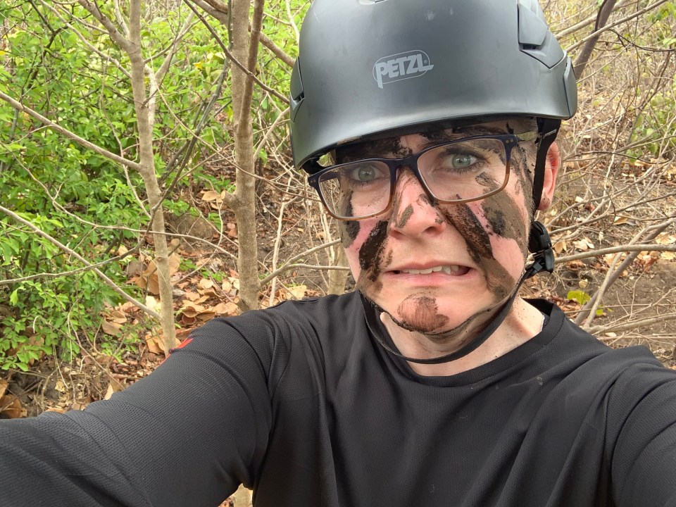 Muddy woman wearing a helmet and glasses.