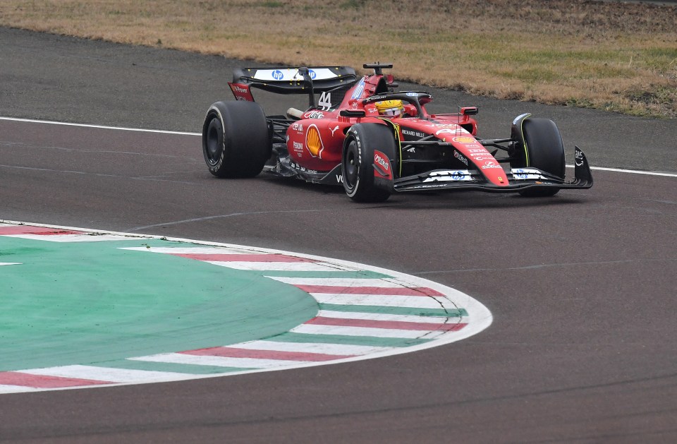Lewis Hamilton driving a Ferrari F1 car on a racetrack.