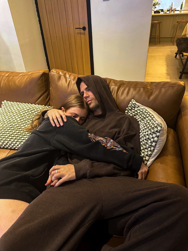 Couple cuddling on a couch.