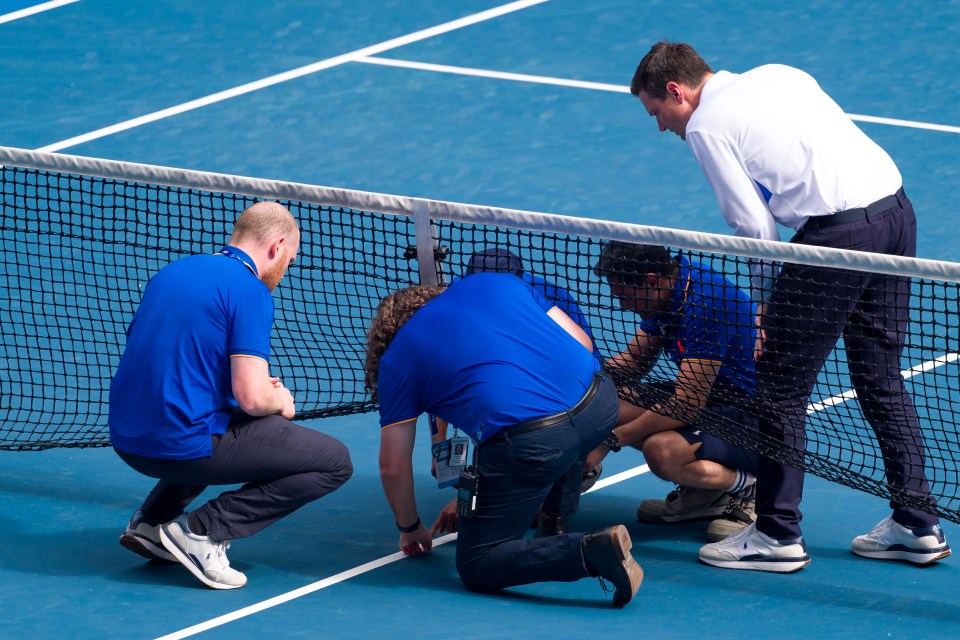 Tennis net repair crew working on a tennis court.