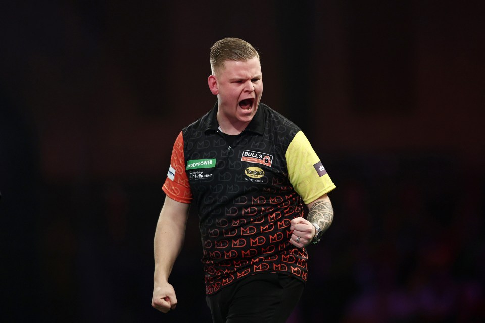 Mike De Decker of Belgium celebrates during a darts match.