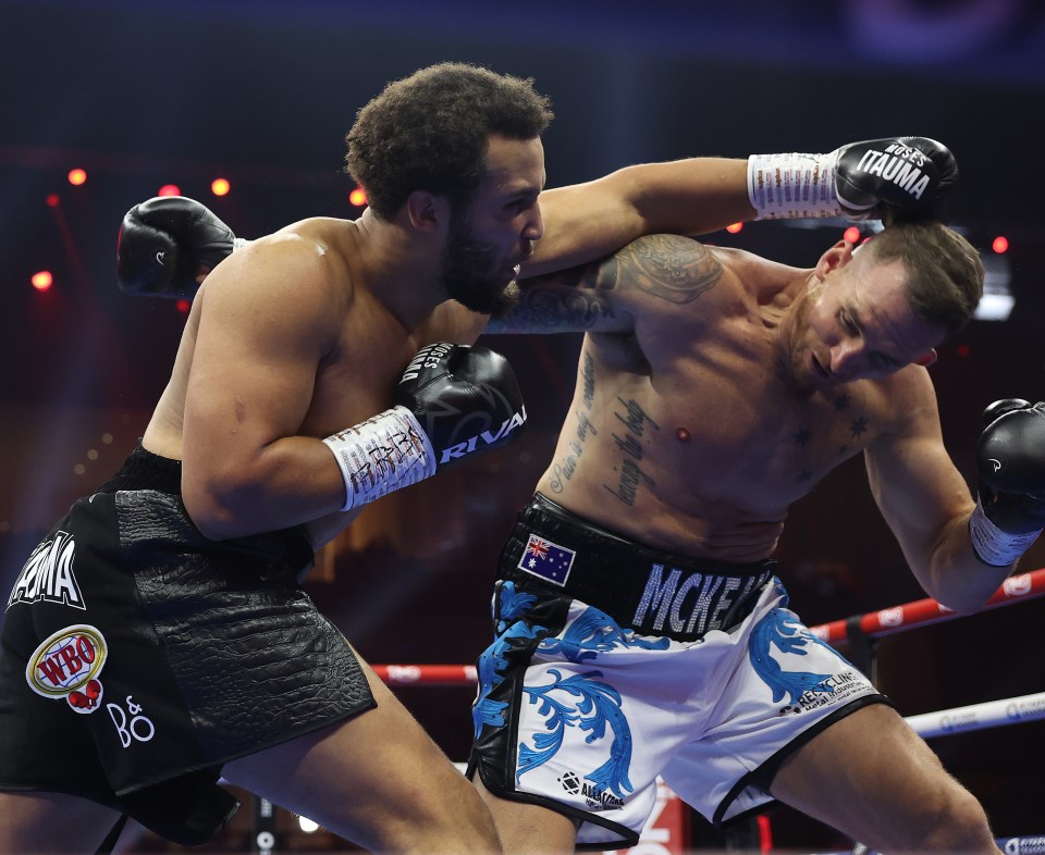 Moses Itauma knocks down Demsey McKean during a boxing match.