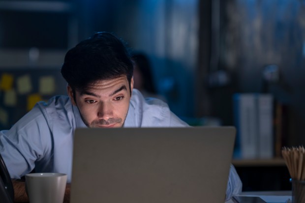 Businessman working late on laptop.