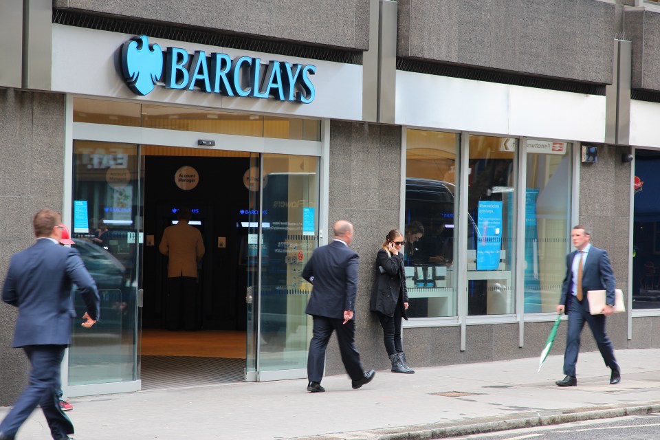 People walking past a Barclays bank branch.