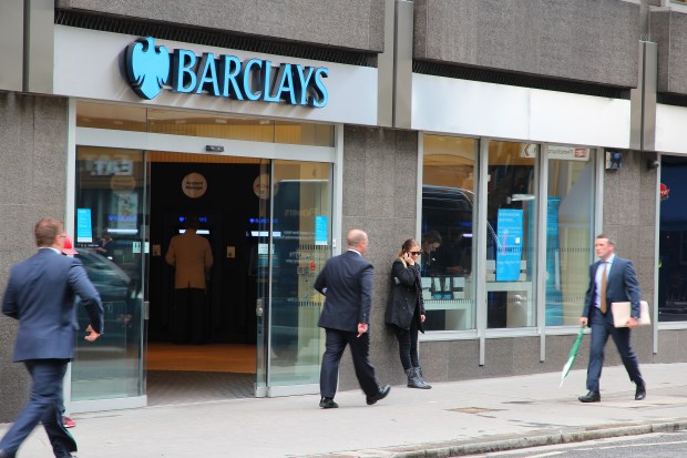 People walking past a Barclays bank branch.