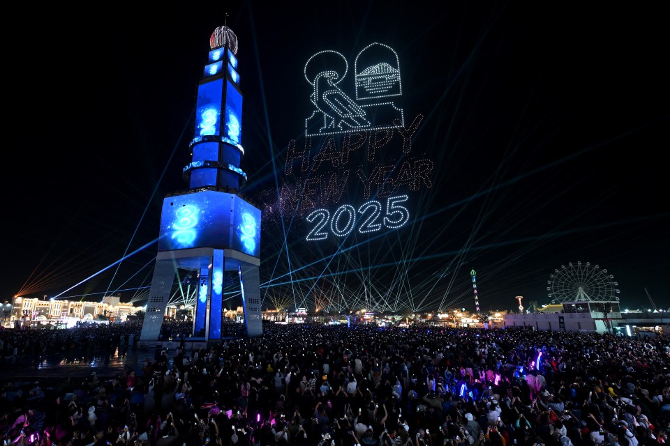 New Year's Eve 2025 celebration with light show and large crowd.