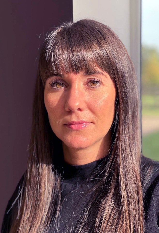Portrait of a woman with long brown hair and bangs.