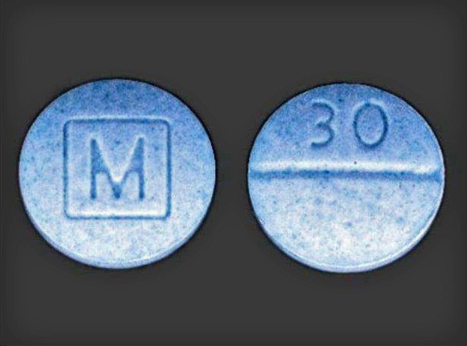 Two blue pills; one marked with an "M" in a square, the other with "30".