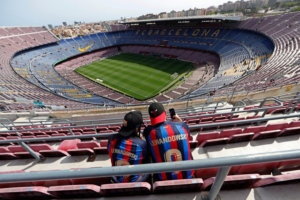 Two Barcelona fans in Lewandowski jerseys at Camp Nou.
