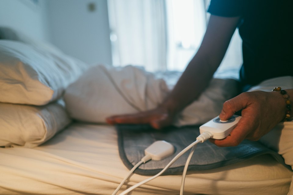 Person using an electric blanket in bed.