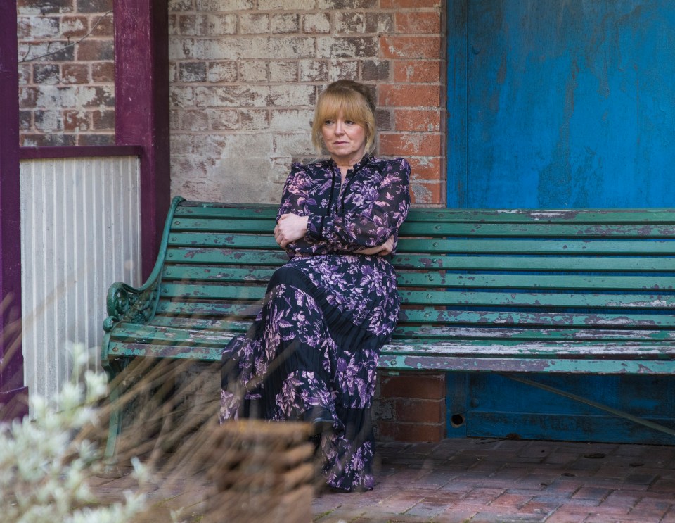 Jenny Connor sits on a bench in Victoria Garden, looking upset.
