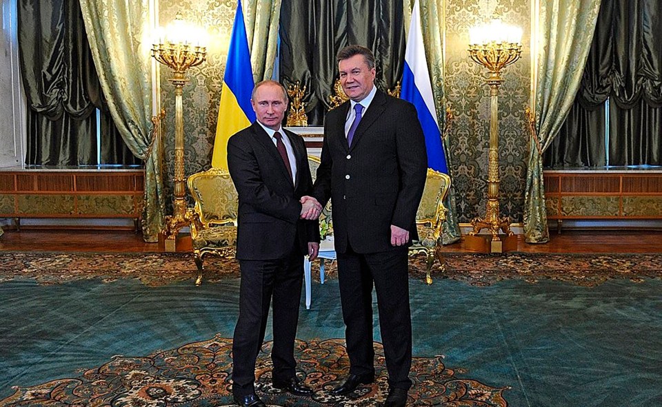 Vladimir Putin and Viktor Yanukovych shaking hands.