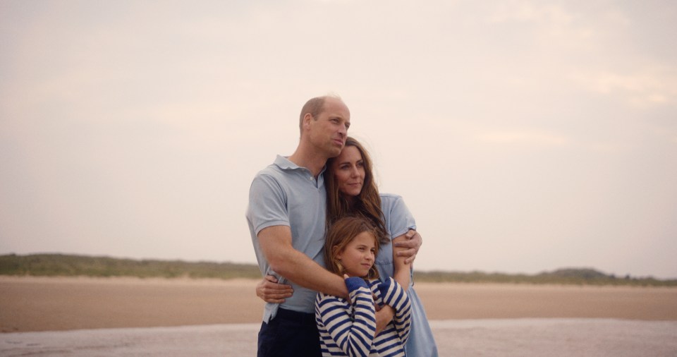 The Prince and Princess of Wales with their daughter Princess Charlotte on a beach.