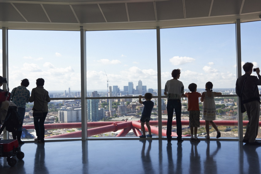 Family silhouetted against London skyline viewed from a tall building.