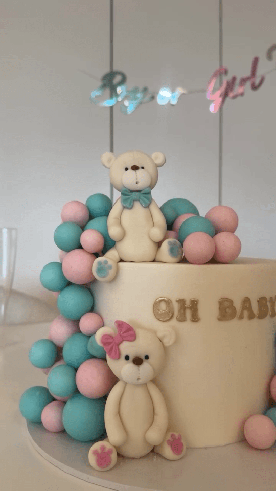 Gender reveal cake with teddy bears and balloons.