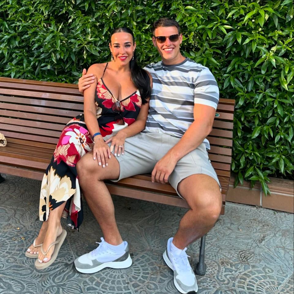 Stephanie Davis and Joseph McKalroy sitting together on a park bench.