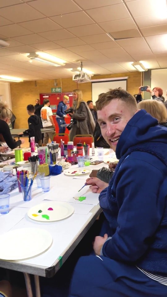 Man painting a Christmas tree at an art event.