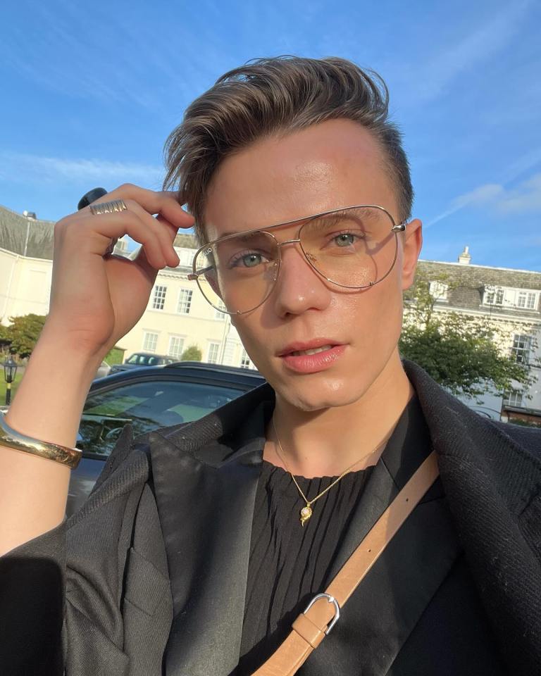 Ronan Parke, wearing glasses and a black jacket.