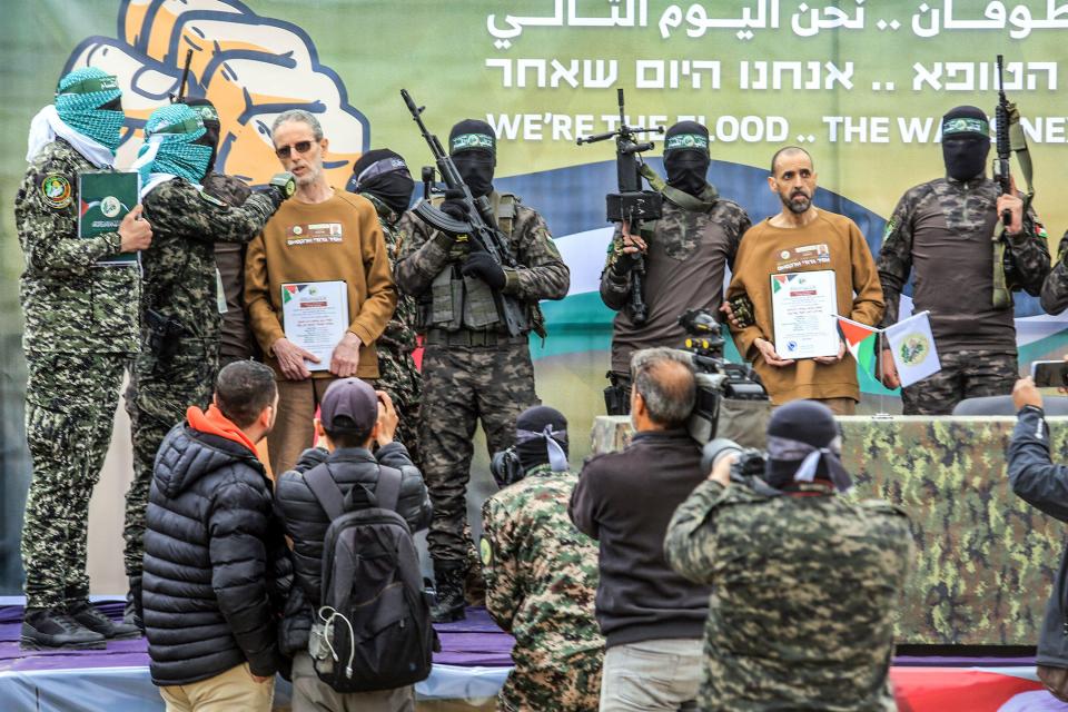 Hamas fighters handing over Israeli hostages.