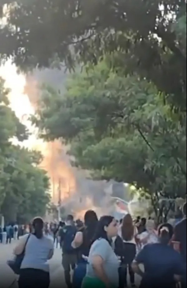Large fire viewed from behind a crowd of onlookers.