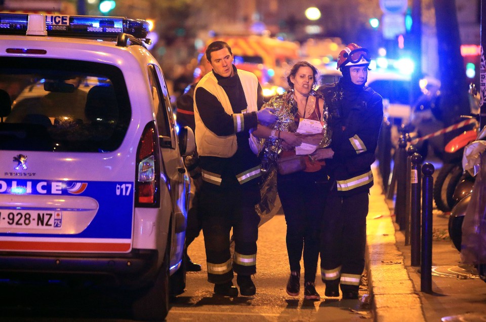 Rescue workers assisting a woman after a terrorist attack in Paris.