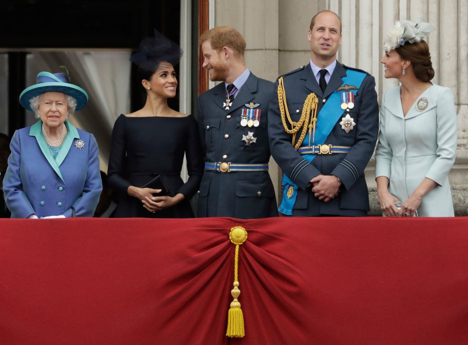 Queen Elizabeth II with Prince Harry, Meghan Markle, Prince William, and Kate Middleton on a balcony.
