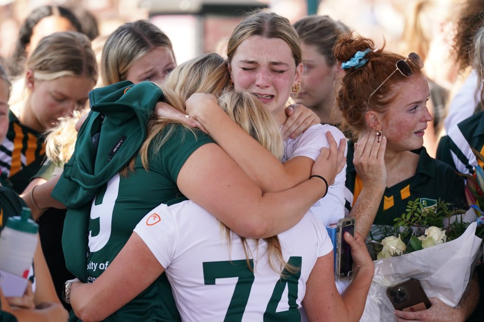 Mourners embracing at a vigil.