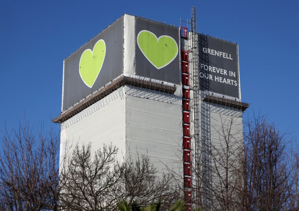 Grenfell Tower wrapped in scaffolding with a banner reading "Grenfell Forever in Our Hearts."