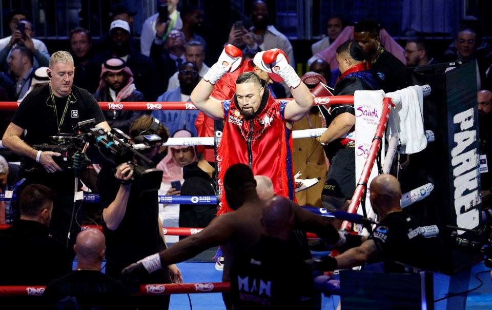 Joseph Parker raises his arms in victory after a boxing match.