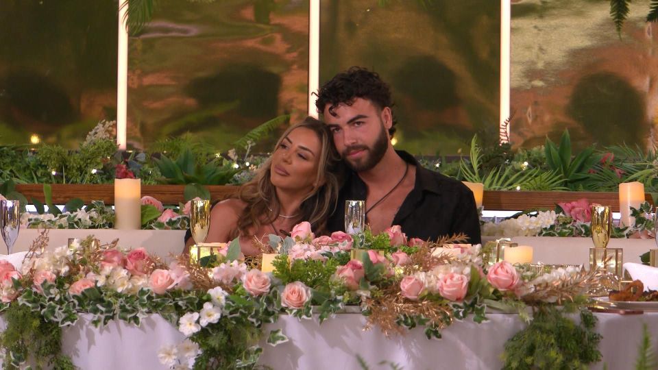 Luca and Harriett from Love Island sitting together at a table.
