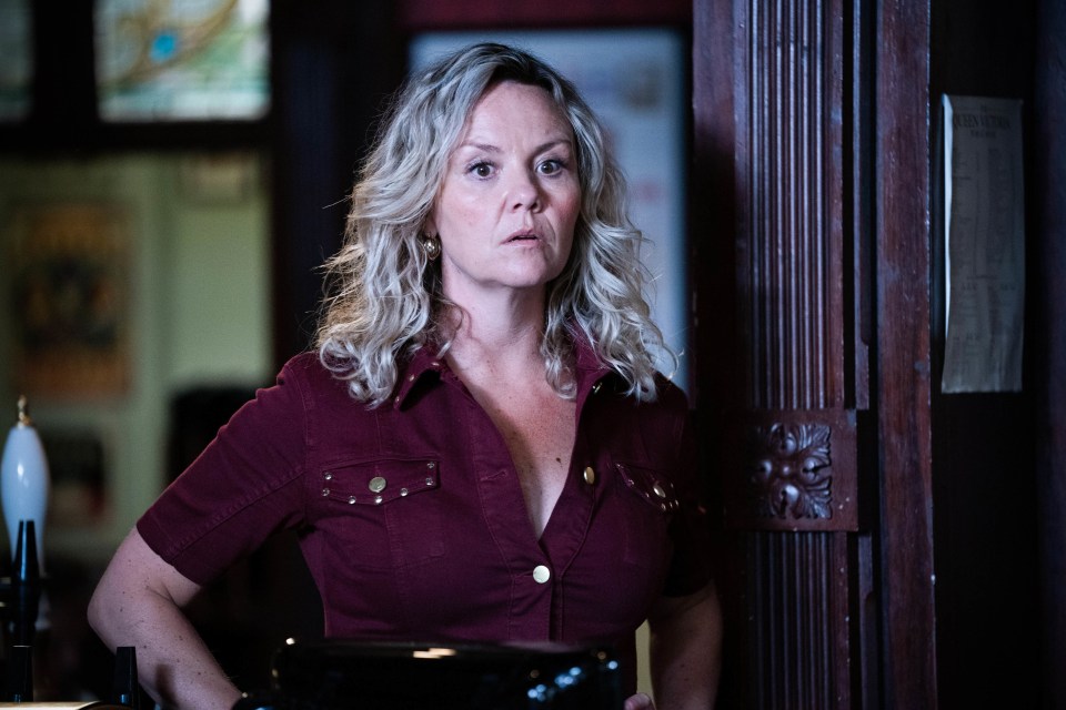 Janine Butcher from EastEnders in a maroon shirt.