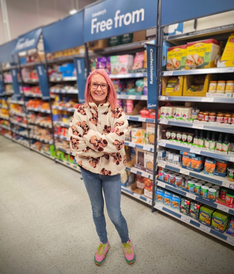 Woman standing in a grocery store aisle with gluten-free products.