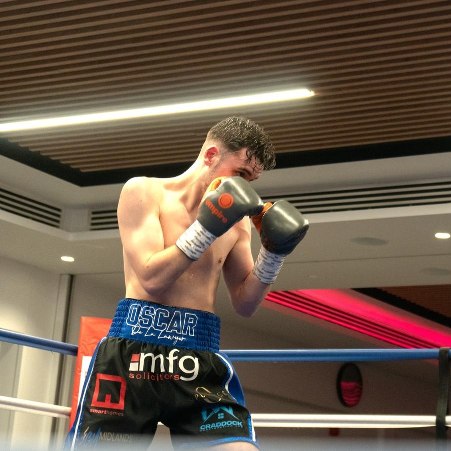 Two boxers facing each other in a boxing ring.