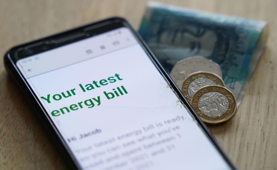 Smartphone displaying an energy bill and British currency.