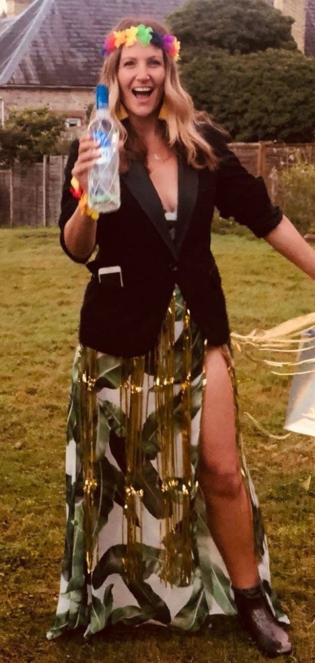 Woman in a tropical-print dress holding a bottle of vodka.