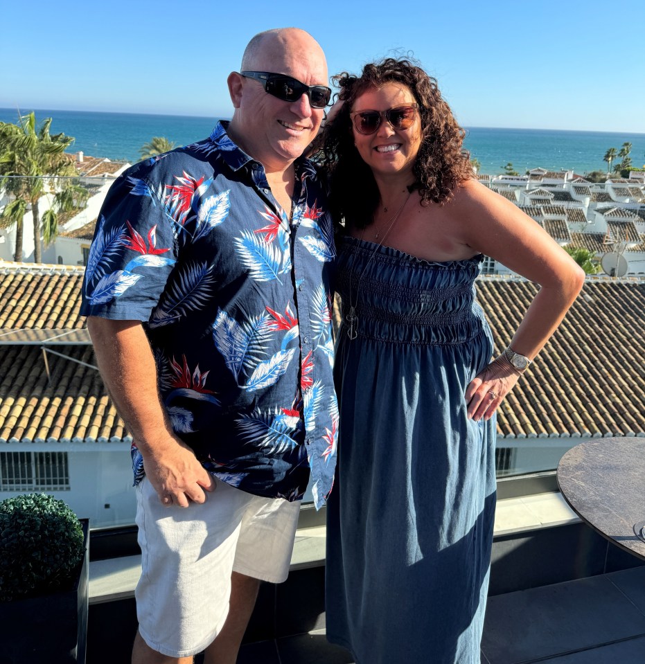Couple posing on a rooftop overlooking the ocean.
