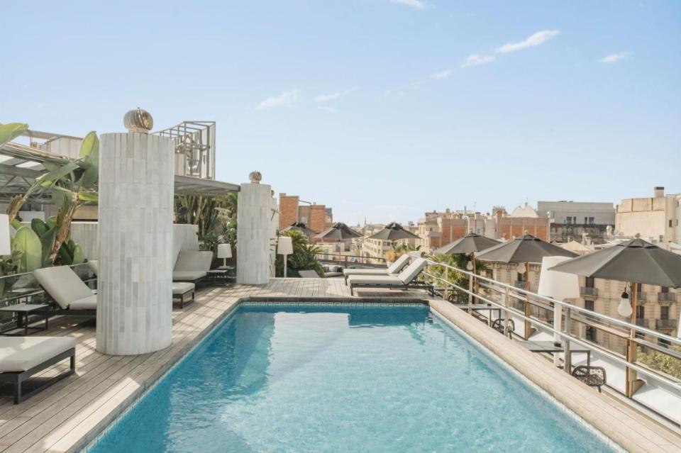 Rooftop pool and lounge area with city view.