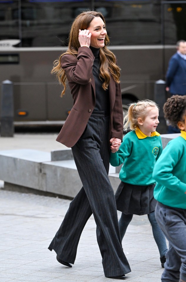 Princess Catherine walking with young children.