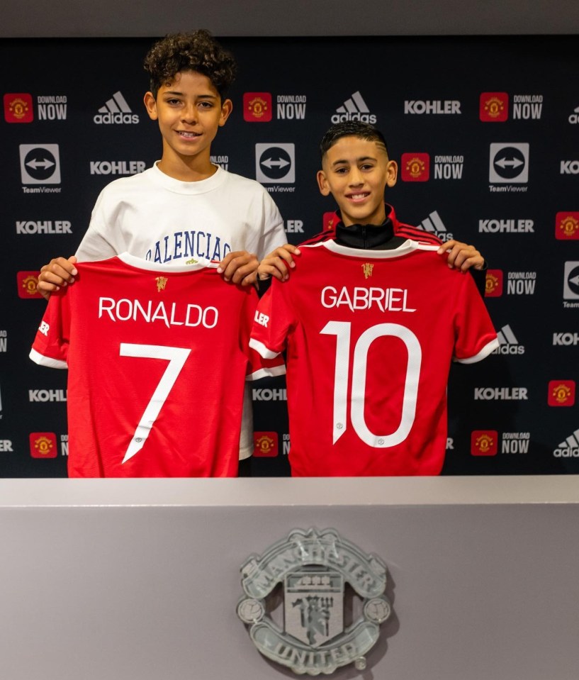 Two boys holding Manchester United jerseys with Ronaldo 7 and Gabriel 10 on the back.