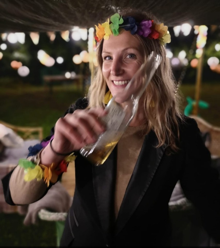 Woman drinking from a bottle at a party.