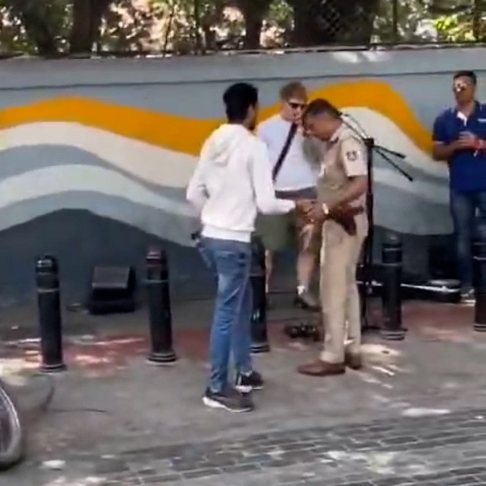Ed Sheeran having his microphone unplugged by Indian police during a street performance.