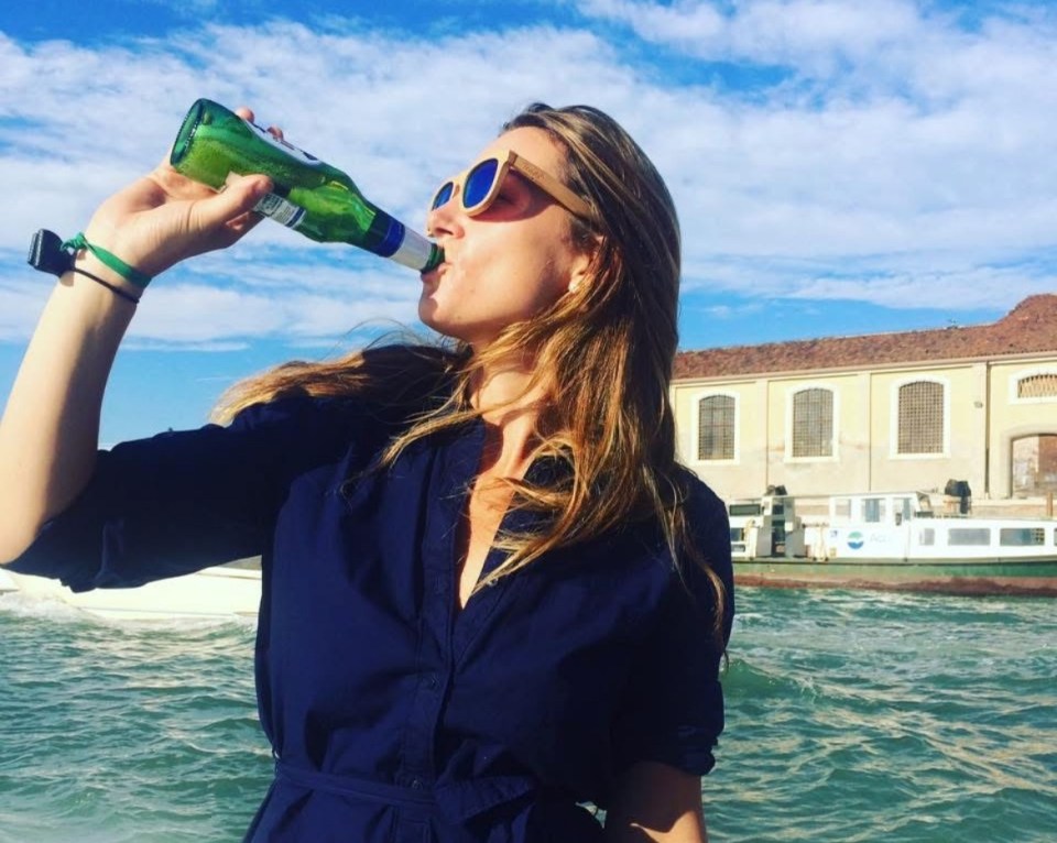 Woman drinking beer outdoors.
