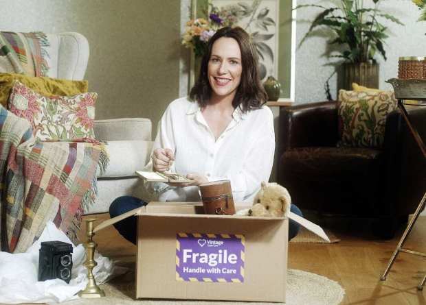 Woman packing a box of fragile items.