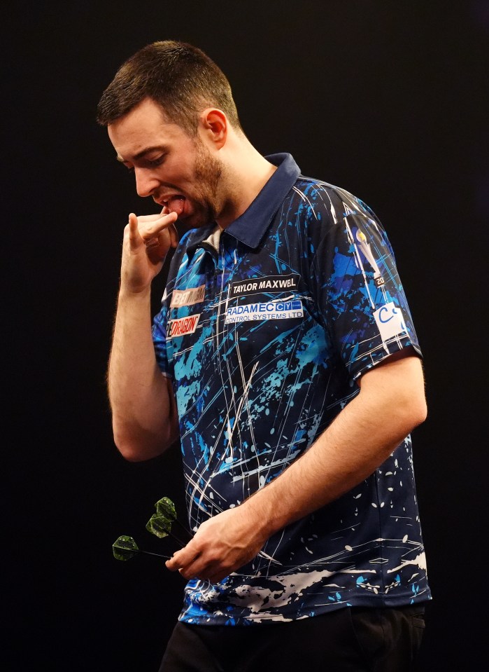 Taylor Maxwell, a darts player, holding three darts.