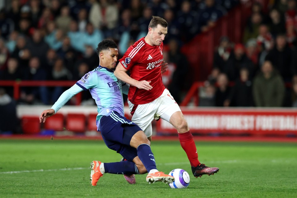 NOTTINGHAM, ENGLAND - FEBRUARY 26: Chris Wood of Nottingham Forest is tackled by William Saliba of Arsenal during the Premier League match between Nottingham Forest FC and Arsenal FC at City Ground on February 26, 2025 in Nottingham, England. (Photo by David Rogers/Getty Images)