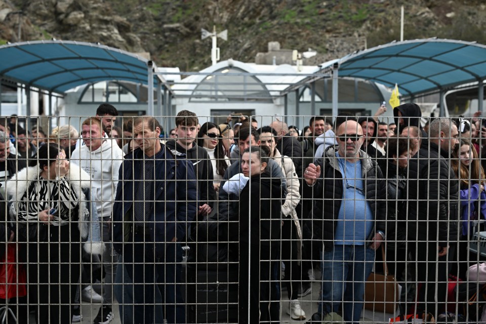 People wait on the quayside to embark a ferry at the port on the Greek Island of Santorini on February 3, 2025, as they prepare to leave in the wake of recurring earthquakes. Fresh overnight tremors shook Greece's top tourist island Santorini, media reports said, prompting people to sleep outdoors and others to leave by plane or ferry. (Photo by Aris MESSINIS / AFP) (Photo by ARIS MESSINIS/AFP via Getty Images)