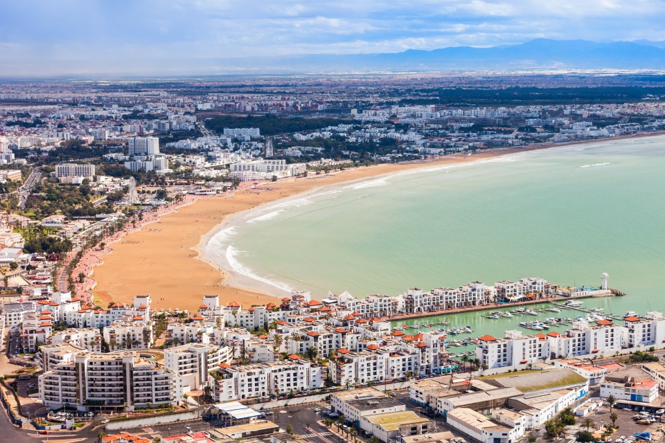 Aerial view of Agadir, Morocco, showing the city, beach, and marina.
