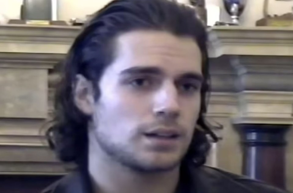 Headshot of a man with long dark hair.
