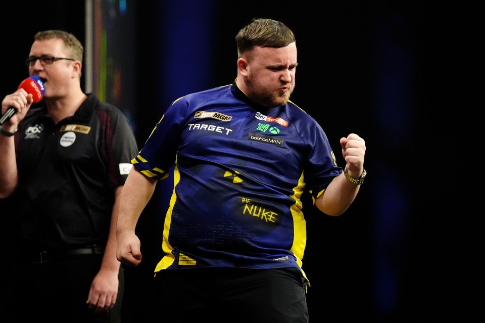 Luke Littler celebrates during a darts match.