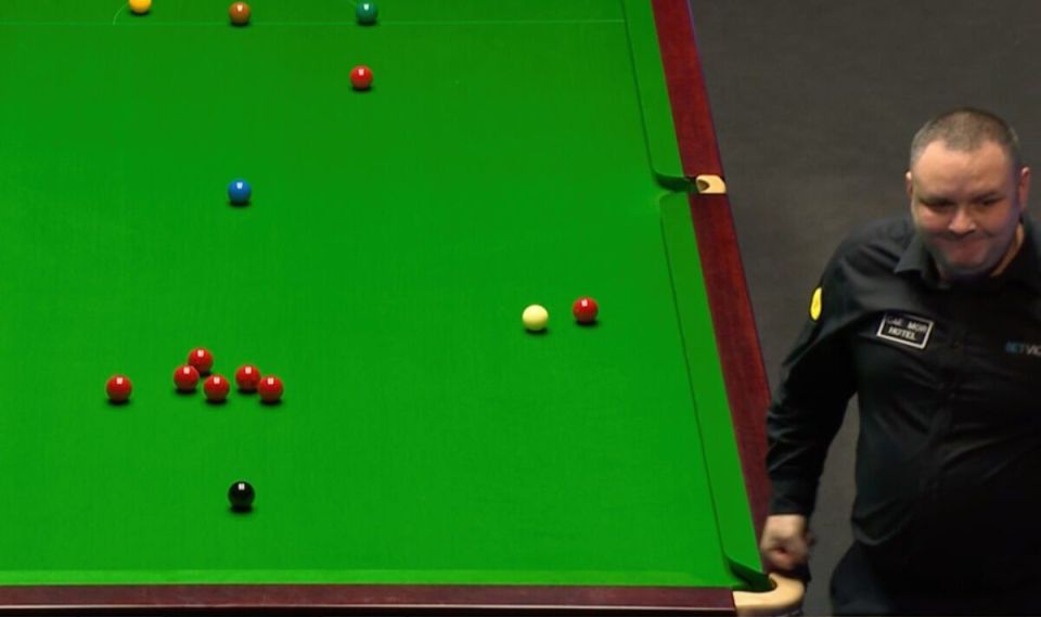 Snooker player leaning over a snooker table.